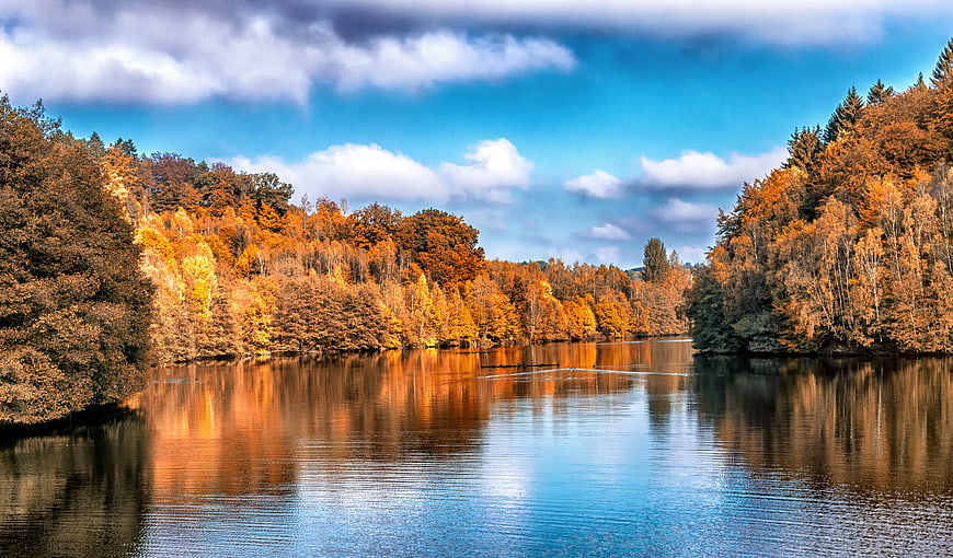 Serene Autumn Lake with Vibrant Orange Forest Reflections