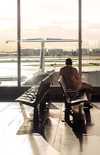 Silhouette of Man Waiting at Airport Terminal Window