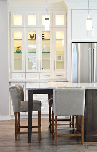 Modern kitchen island with gray bar stools and white cabinets