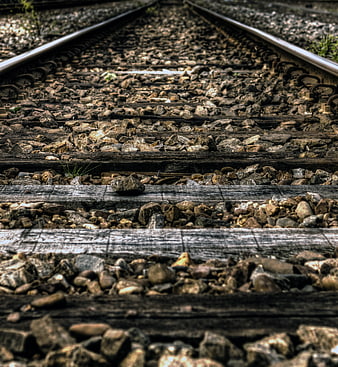 Close-up of weathered railroad tracks with gravel and wooden ties