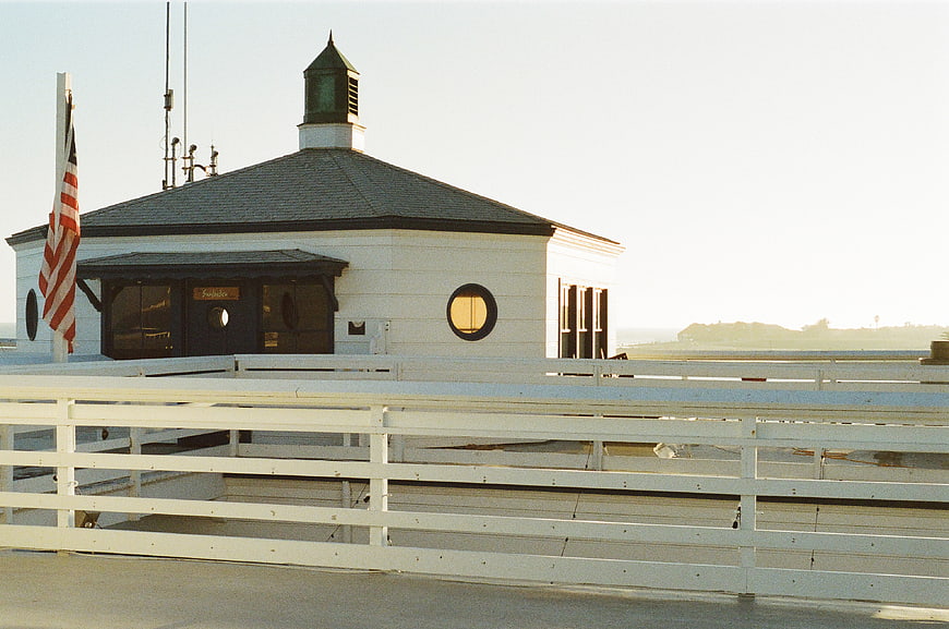 White Pier Building with American Flag and Wooden Railing
