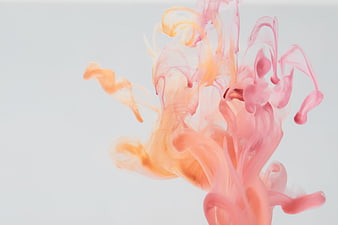 Abstract pink and orange ink swirling in water