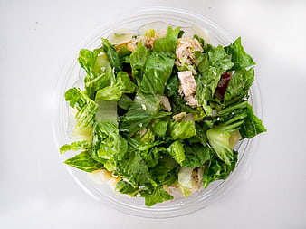 Top view of fresh Caesar salad in plastic container