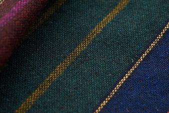 Close-up of textured plaid fabric with blue, green, and gold stripes