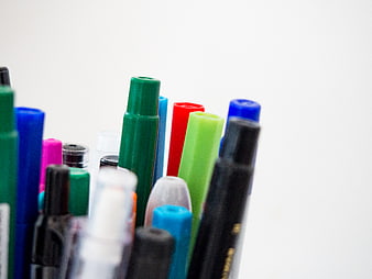 Close-up of colorful markers and pens on white background