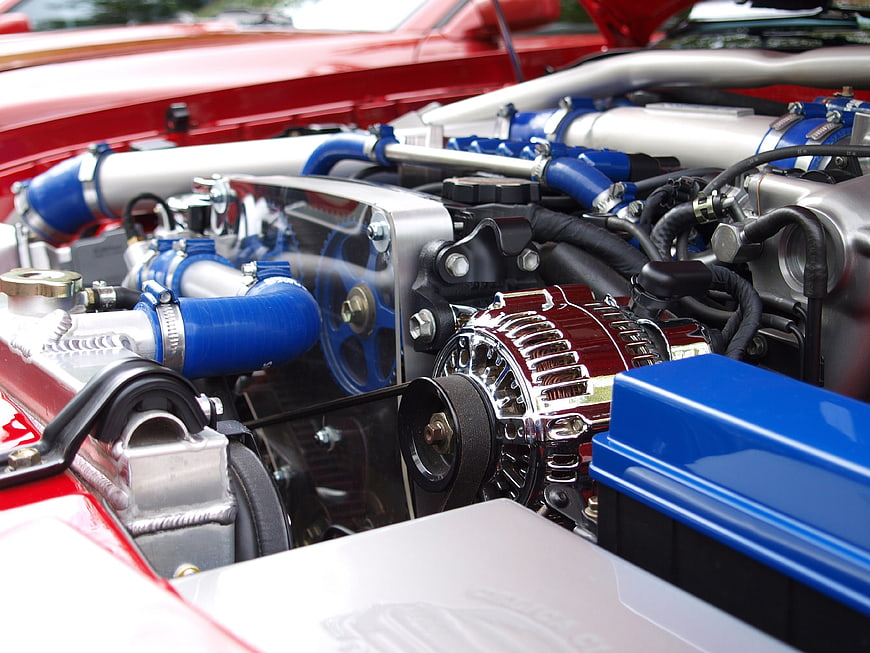 Close-up of a red classic car engine with blue and chrome details