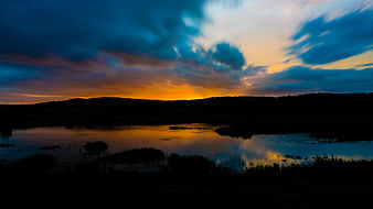 Dramatic sunset over a lake with long exposure clouds