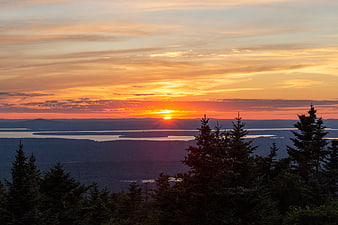 Vibrant Sunset Over Lake and Forested Hills