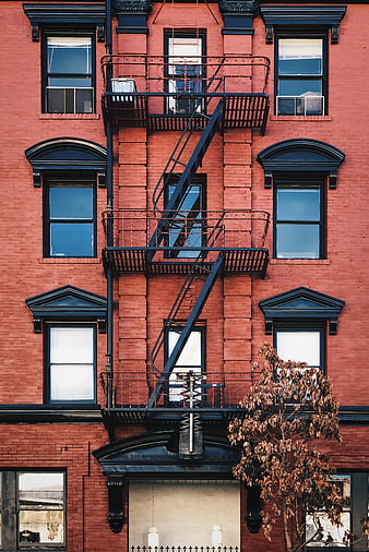 Red brick building facade with black fire escape stairs