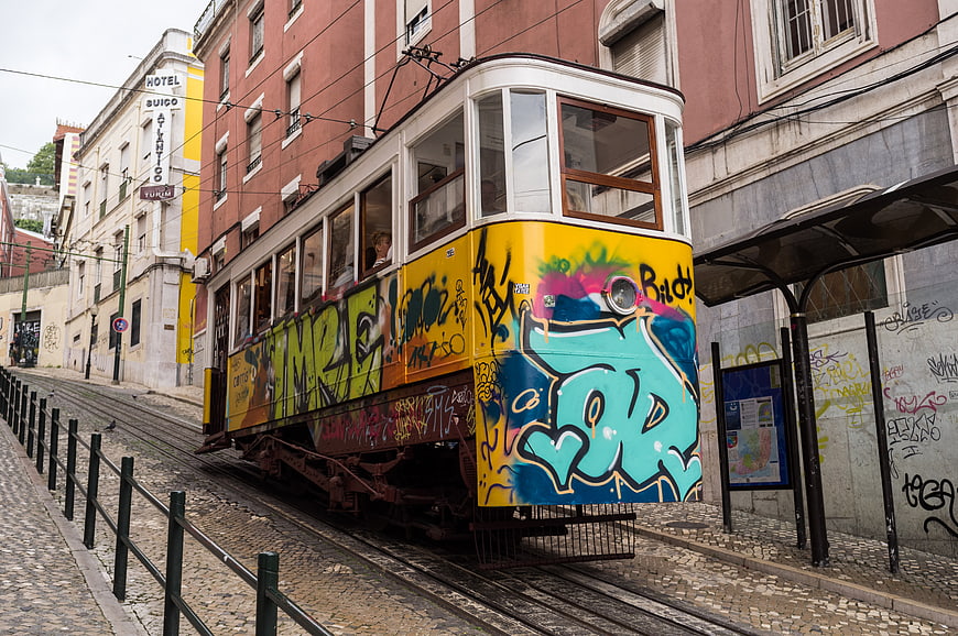 Colorful Graffiti Tram on Cobblestone Street in Lisbon