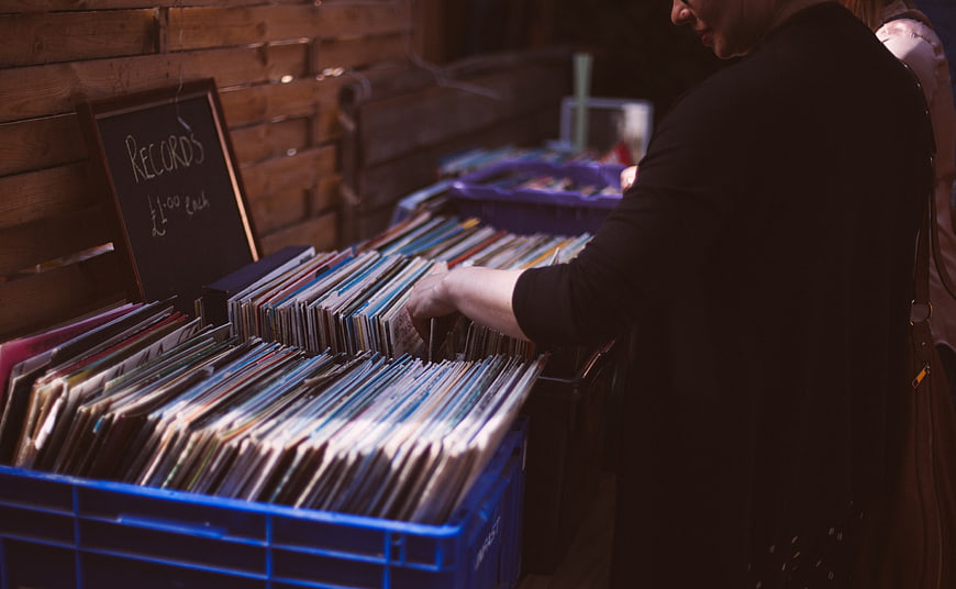 Woman browsing vinyl records at a vintage market stall