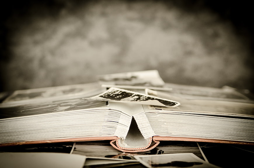 Vintage open photo album with scattered black and white memories