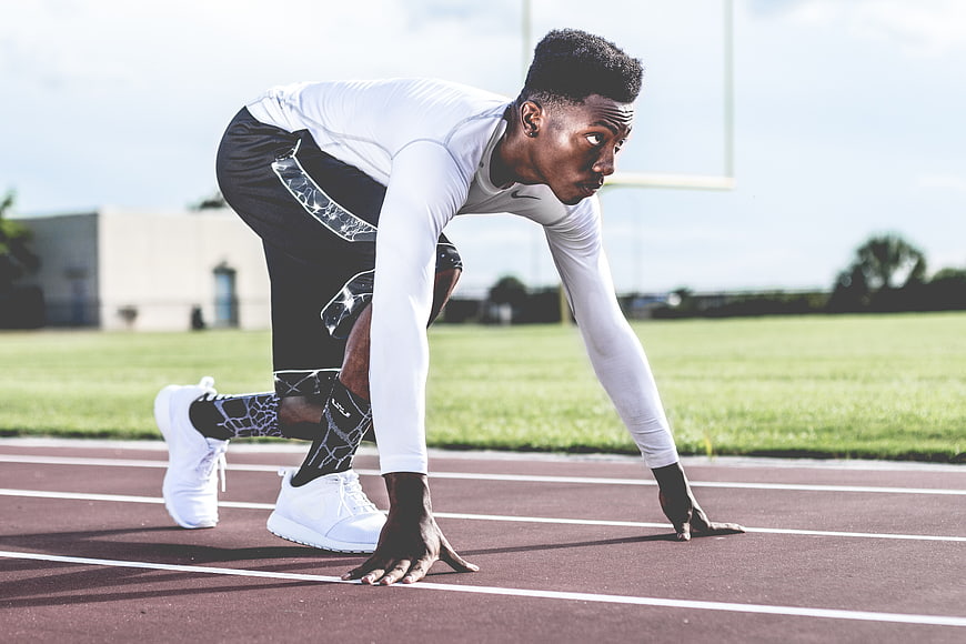 African American Sprinter in Starting Position on Track