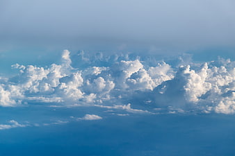 White Cumulus Clouds Against Blue Sky Background