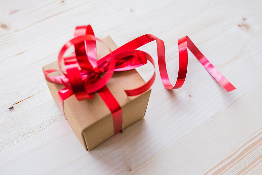 Brown Gift Box with Red Ribbon on White Wood