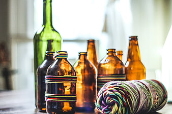 Vintage glass bottles and colorful yarn skein on rustic table