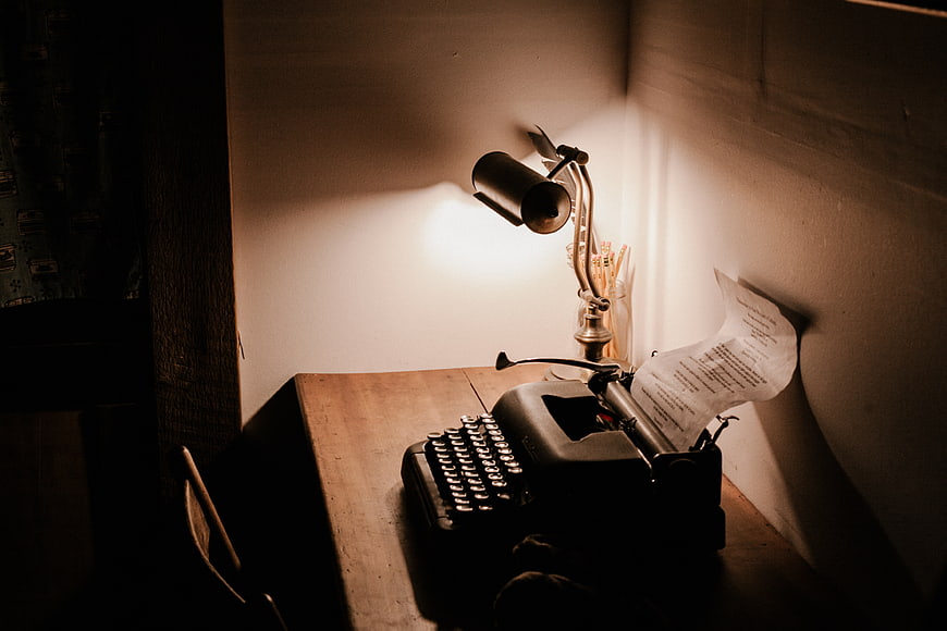Vintage Typewriter on Wooden Desk with Lamp