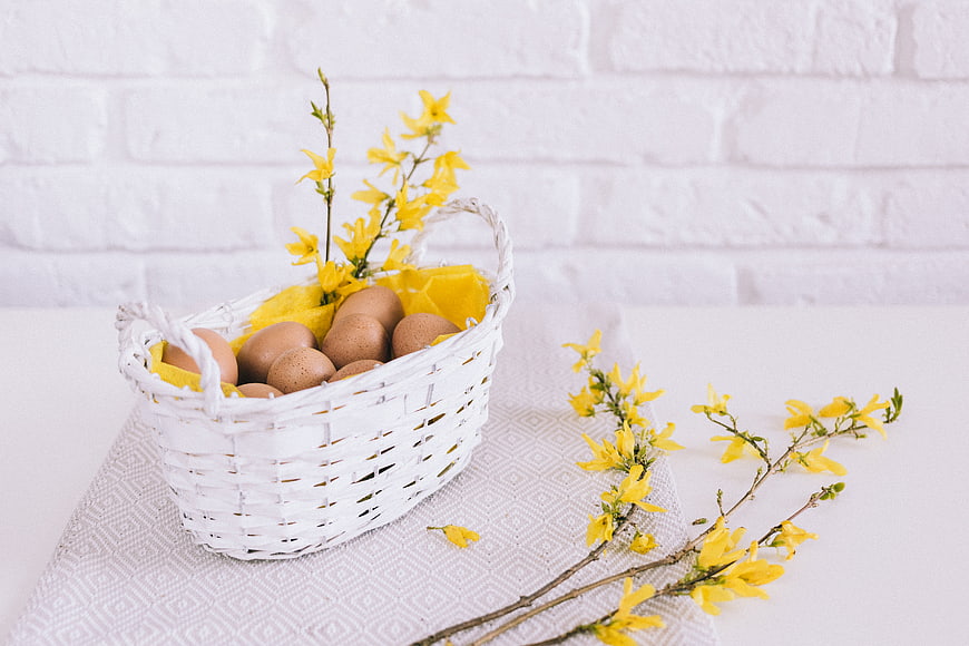 White Easter Basket with Brown Eggs and Yellow Flowers