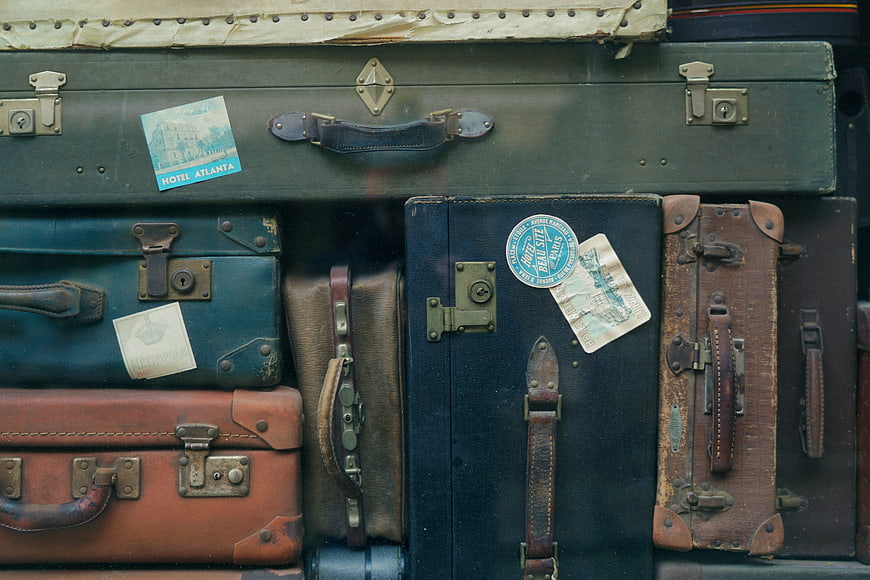 Vintage Suitcases with Travel Stickers and Luggage Tags