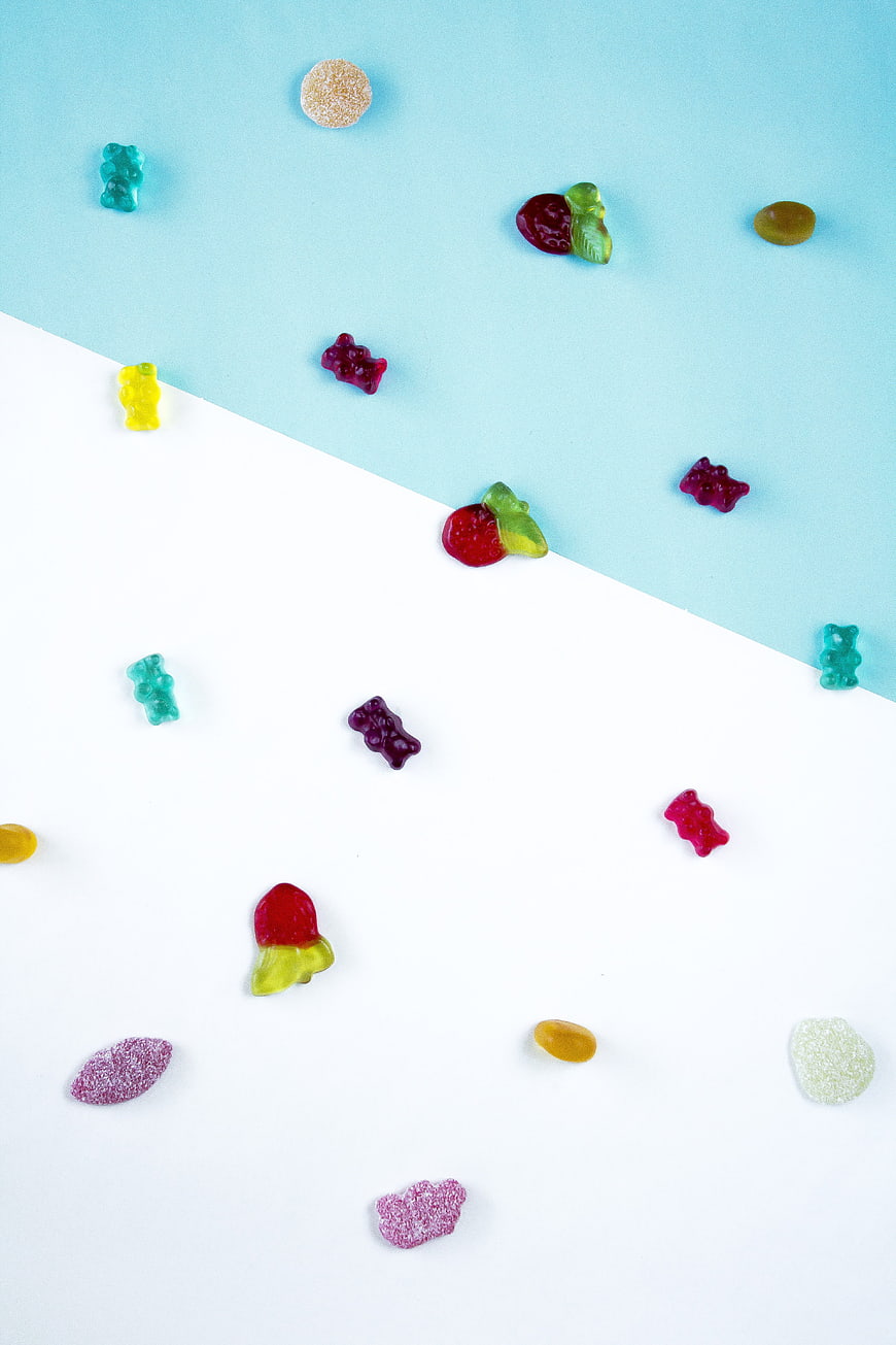 Colorful Gummy Bears and Candy on Split Blue and White Background