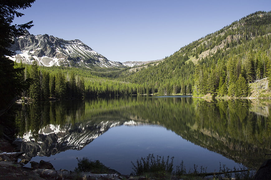 Serene Mountain Lake with Forest Reflections and Snowy Peaks