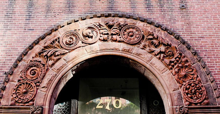 Ornate Stone Archway on Red Brick Building Exterior