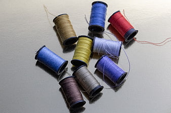 Colorful Spools of Sewing Thread on Gray Surface