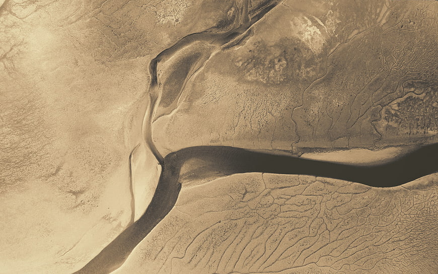 Aerial view of winding river through desert landscape