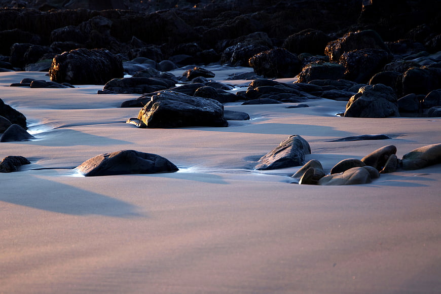 Long Exposure Rocky Beach at Sunset with Smooth Water