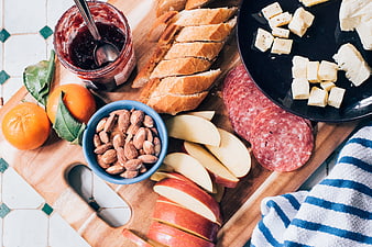 Overhead view of charcuterie board with bread, cheese, and fruit