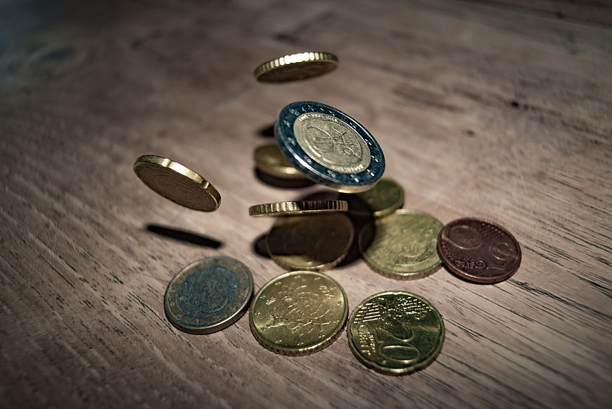 Falling Euro coins on wooden table