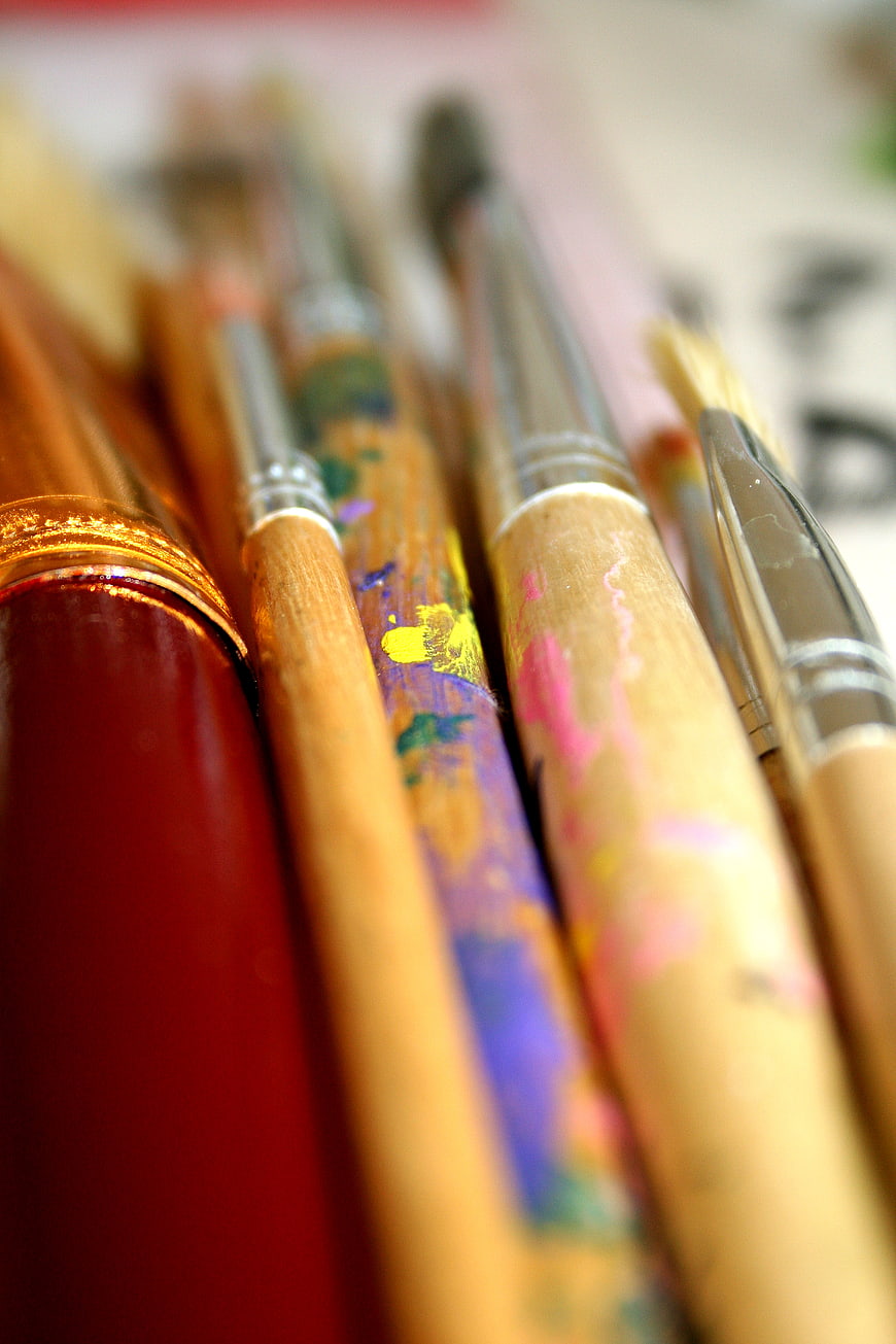 Close-up of colorful paint-splattered artist brushes
