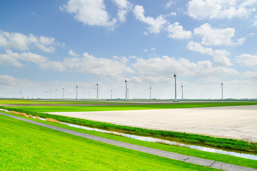 Wind turbines in green agricultural landscape with blue sky