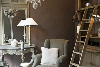 Elegant interior with gray armchair, wooden ladder, and vintage console table