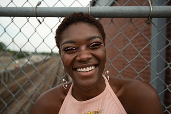 Portrait of smiling Black woman with pink eyeliner outdoors