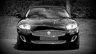 Front view of black Jaguar XK with bright headlights