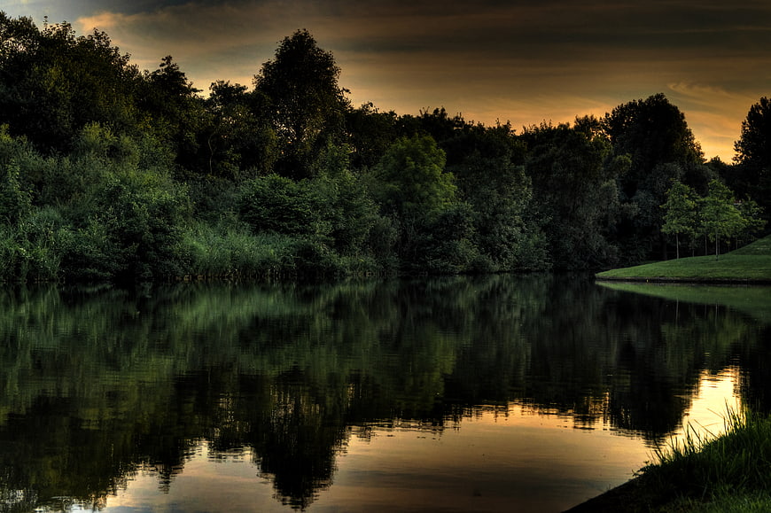 Dramatic HDR Lake Reflection at Dusk with Dark Trees