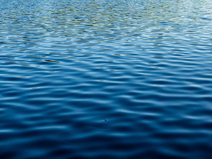 Deep Blue Water Surface with Gentle Ripples and Reflections