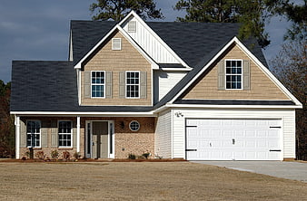 Modern two-story suburban house with beige siding and white garage