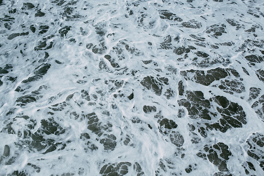 Aerial View of Foamy Ocean Waves and Sea Foam