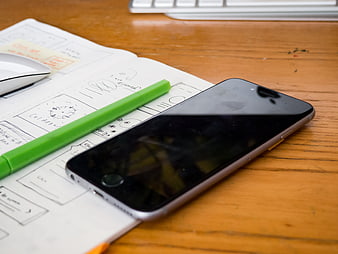 Smartphone and wireframe sketches on wooden desk