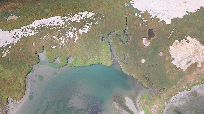 Aerial View of Arctic Tundra, River Delta, and Snow Patches