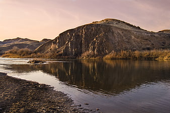 Serene River Landscape with Rocky Cliff at Sunset