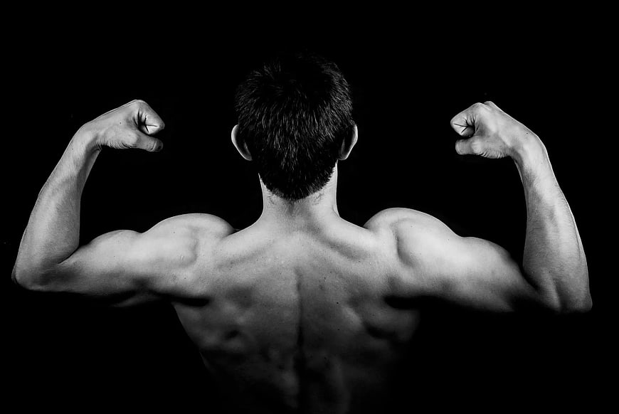 Muscular Man Back View Flexing Biceps in Black and White