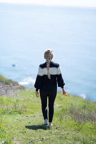 Woman Walking on Coastal Path with Ocean View