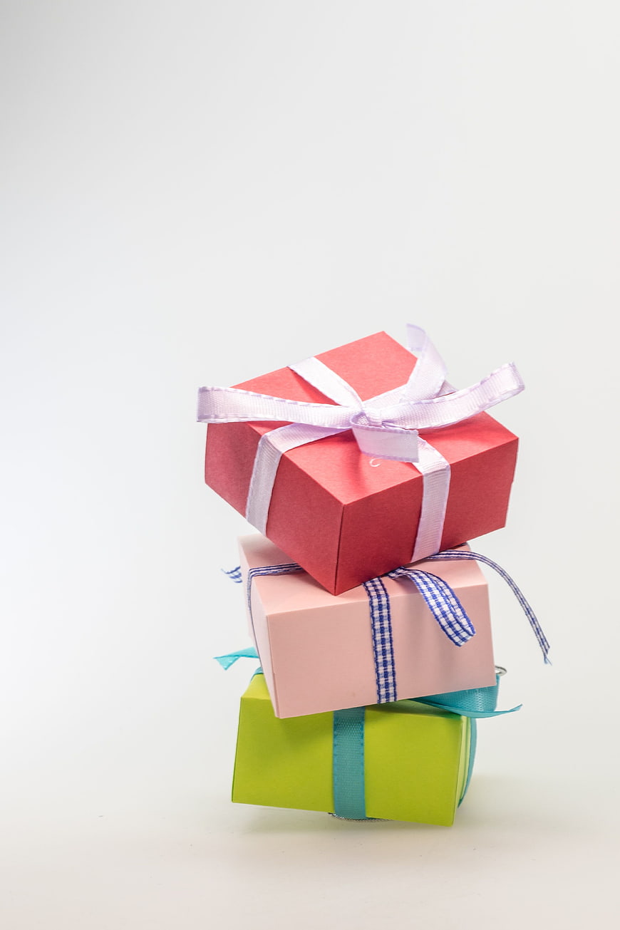 Stacked colorful gift boxes with ribbons on white background