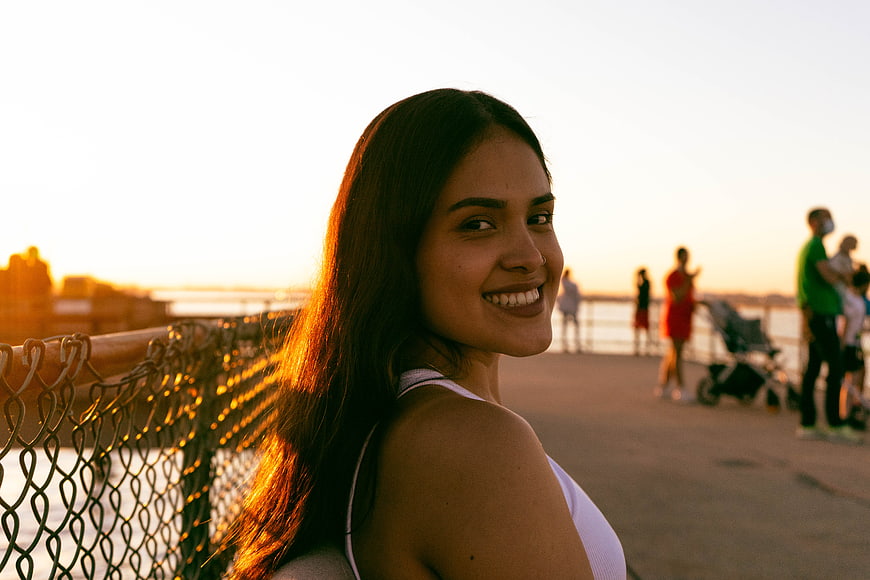 Smiling Brunette Woman at Sunset on Urban Boardwalk