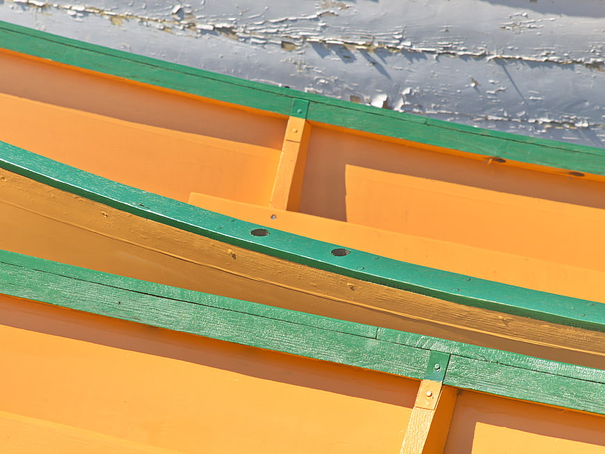 Abstract detail of orange and green wooden boat hull
