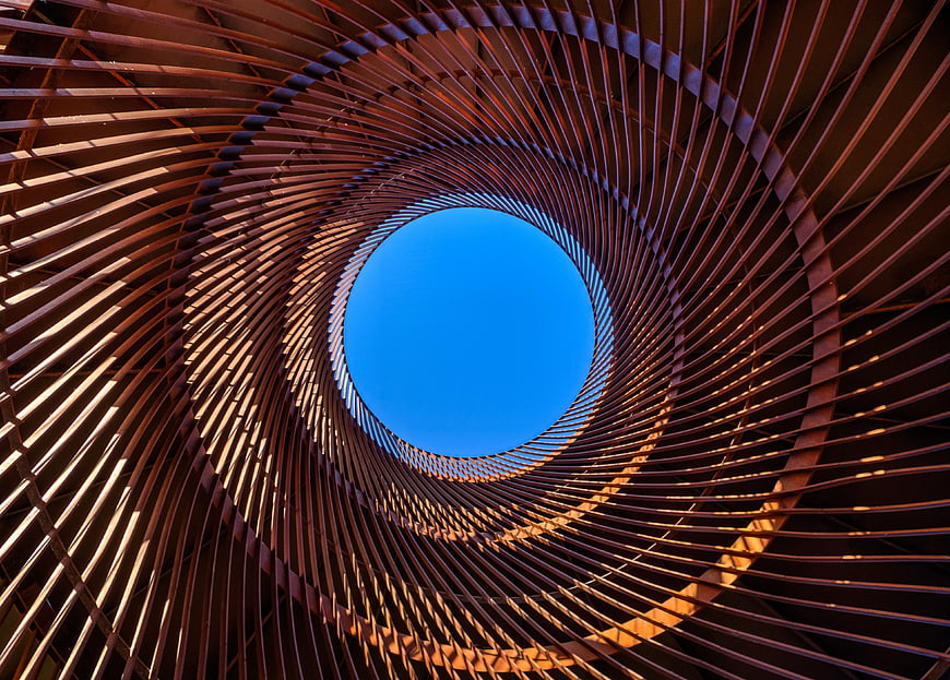 Spiral metal structure looking up at blue sky