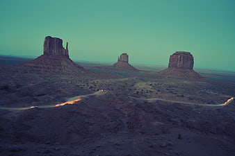 Aerial View of Monument Valley Buttes at Dusk with Car Trails
